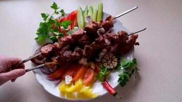 Traditional Russian shashlik on a barbecue skewer with paprika as closeup on an old board video