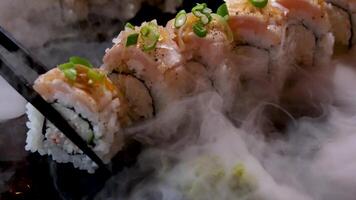 heerlijk restaurant Aziatisch voedsel sushi Aan bord met droog ijs paling tonijn reeks omhullend allemaal in de omgeving van ruimte voor tekst reclame sushi portie menu chef cursussen sushi maker detailopname ongelooflijk heerlijk video