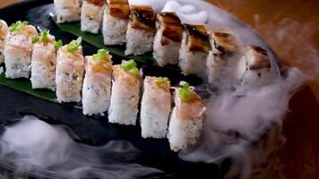 delicious restaurant asian food sushi on plate with dry ice eel tuna set enveloping all around space for text advertising sushi serving menu chef courses sushi maker close-up incredibly delicious video