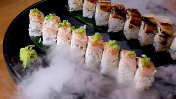 delicious restaurant asian food sushi on plate with dry ice eel tuna set enveloping all around space for text advertising sushi serving menu chef courses sushi maker close-up incredibly delicious video