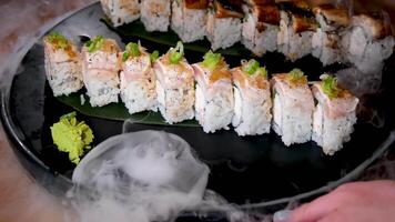 uppsättning av sushi på torr is ånga gejsrar upp stor puffar av vit rök spridning kalifornien med dysterhet och kalifornien med tonfisk utsökt mat vackert eras i restaurang av flott hotell i vancouver video