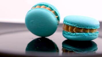 tourbillonnant bleu macaron lavande ou bru fromage saveur sur noir assiette tourbillonnant délicieux dessert restaurant portion douceur français dessert le déjeuner chef plat beaucoup de garnitures amande farine lent mouvement video