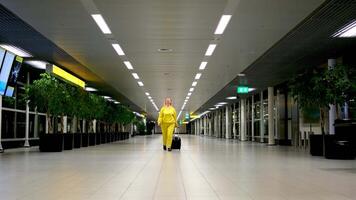 contento giovane sorridente donna a piedi con bagaglio a aeroporto terminale, allegro mezzo orientale femmina Tenere passaporto con Biglietti e trasporto valigia mentre andando per volo partenza cancello, copia spazio video