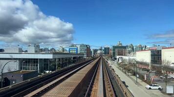 sky train road from Surrey to Vancouver passing trains skyscrapers office buildings science center and other stations from King George to Waterfront real life in a big city british columbia 2023 video