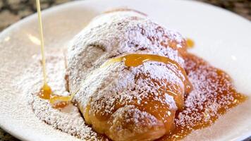 långsam rörelse skott av skön mandel croissanter i en tallrik varelse pulveriserad med vit socker i omvänd glida skott från rätt till vänster video