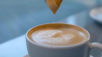 large cup of cappuccino with milk foam in the morning overhead shot cup of coffee latte in shape of a heart and coffee beans on an old wooden background Eating Foam Or Thick Froth Of Hot Coffee Latte video