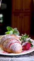 fermer de croissant saupoudré portion cuisinier à Accueil décorer beaucoup différent s avec des fraises et Chocolat saupoudré avec sirop saupoudré avec différent garnitures Photos et s video