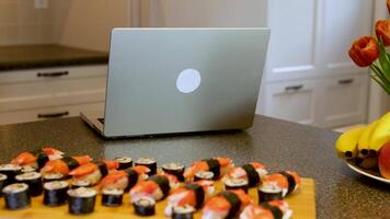 tipo e ragazza nel cucina mangiare Sushi, Guardando un' film, parlando, gli amici, comunicare, avendo divertimento. le persone, tempo libero, mangiare, coppia con smartphone assunzione immagine di Sushi a ristorante video