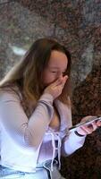 jong charmant vrouw roeping met cel telefoon terwijl zittend alleen in koffie winkel gedurende vrij tijd, aantrekkelijk vrouw met schattig glimlach hebben pratend gesprek met mobiel telefoon terwijl rust uit in cafe video