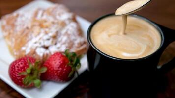 nemen gebakje uit de tafel met ochtend- koffie thee en bakkerij met aardbeien. knus keuken, huiselijk atmosfeer hoog kwaliteit 4k beeldmateriaal video