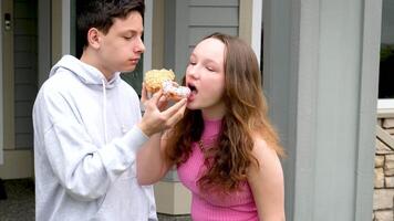 le gars traite le sien bien-aimée avec une délicieux Donut. une gars et une fille sont repos video