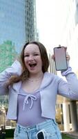 Young adult elegant successful beautiful business woman, happy professional businesswoman executive holding cellphone using smartphone modern tech standing on big city urban street outside. video