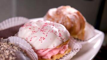 buffet servendo dolce delizioso dolci di vario tipi con cioccolato bianca glassa in polvere zucchero crema su il tavolo avvicinamento lento movimento di un' varietà di dolci video