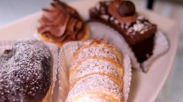 bufê servindo sobremesa delicioso doces do vários tipos com chocolate branco geada em pó açúcar creme em a mesa fechar-se lento movimento do uma variedade do sobremesas video