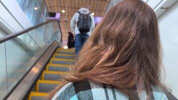 escalator girl with her back to the camera goes up to the skytrain in Surrey Vancouver Canada video