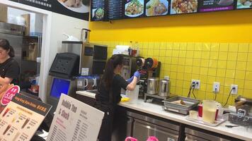 rápido comida café rápido comida mujer muchachas Cocinando joven niña en un azul blusa esperando para su orden menú fotos de platos ordinario restaurante sencillo comida en Vancouver Canadá video