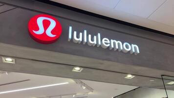 Lululemon buying sportswear gray tracksuit in store at the checkout girl seller puts new clothes in a bag young woman teenager buys a lot of bags rejoicing happy having a good time and shopping video