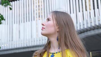 Young blonde woman looking to the sky with serious expression at street video