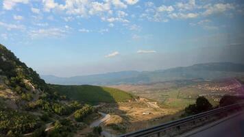 ver desde el ventana de el montañas de Albania paso vehículos en el la carretera ligero nublado cielo verano ruta viaje viaje video