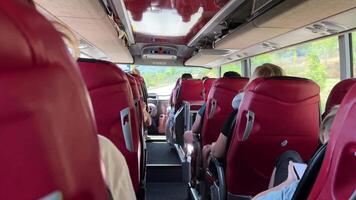 tourist bus red chairs people sitting in them unrecognizable people going on an excursion to another country travel road expectation reality video
