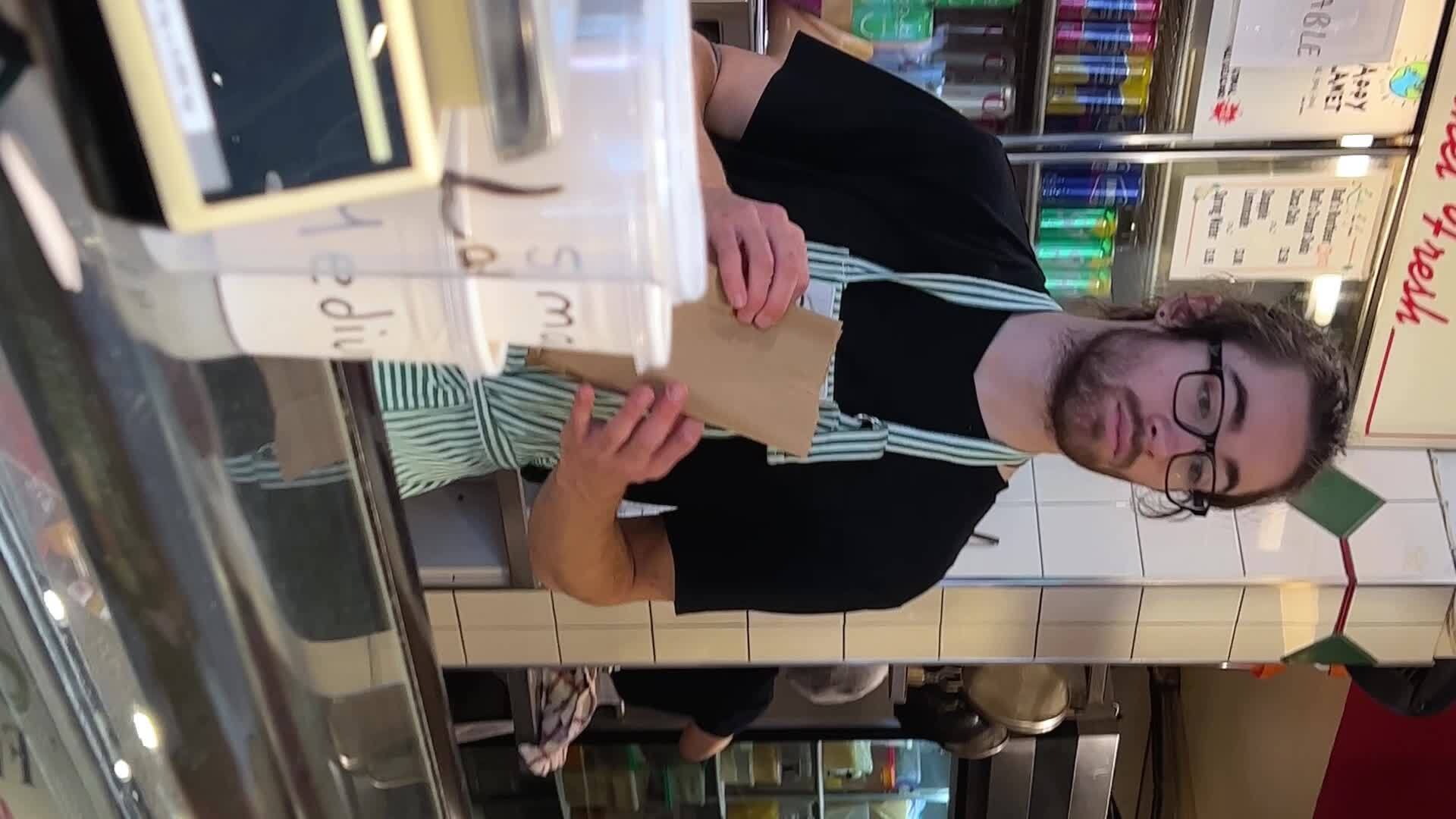 Granville Island A man with long hair, a black beard and an apron He approaches the buyers, he