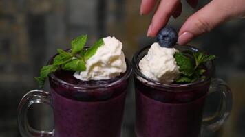 Fresh red fruits smoothie on vintage decorated wooden table. video