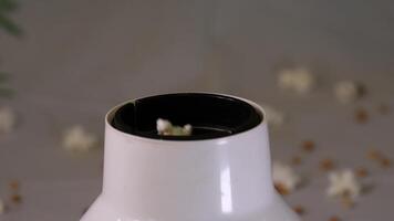 Popcorn falling on rotating wooden table full of corns in slow motion. video