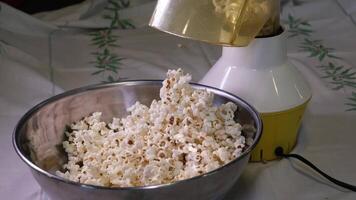Popcorn falling on rotating wooden table full of corns in slow motion. video