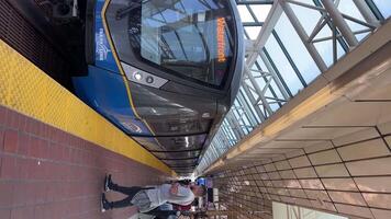 New Surrey train arriving Vancouver skytrain People enter the train at the end a woman with a child and a carriage is trying to get into the carriage a Muslim woman in a long dress and a headscarf video