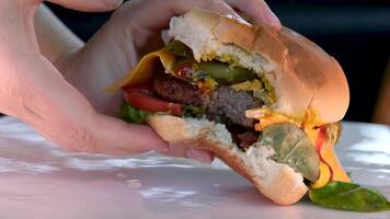 il capocuoco arriva per il tavolo e mette un' delizioso Hamburger, mani nel nero guanti. nutriente prima colazione. video