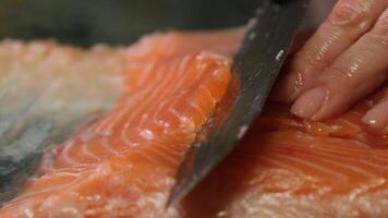 red fish salt chef cuts a fillet of fresh red fish with a knife. Cooking salmon raw meat for steak slow motion close up view video