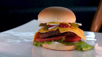 a chefe de cozinha vem para a mesa e coloca uma delicioso Hamburger, mãos dentro Preto luvas. nutritivo café da manhã. video