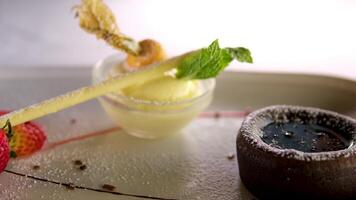 Delicious fresh fondant with hot chocolate and mint on white plate, closeup vanilla ice cream physalis video