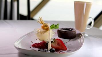 chocolate fondant en un blanco plato con oscuro chocolate hielo crema fresas gotas de jarabe hermosa servicio en un costoso restaurante postre comida video