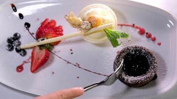 Essen Brownie mit Gabel. nehmen beißen von Schokolade Kuchen mit Schokolade Glasur und Erdbeeren video