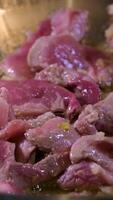 Hinzufügen gehackt Knoblauch und Ingwer zu Rindfleisch im ein braten schwenken braten roh Fleisch im Olive Öl Nahansicht orientalisch Essen Nudeln Wok Start von Kochen heiß Öl spritzt roh Fleisch während Kochen video