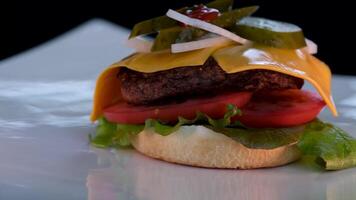 de chef komt naar de tafel en zet een heerlijk Hamburger, handen in zwart handschoenen. voedzaam ontbijt. video