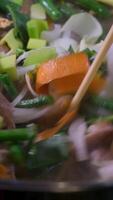 Closeup overhead shot of cooking oil being poured from a bottle over a variety of raw chopped vegetables, ready for frying or baking. video