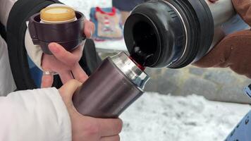 mulher derramando chá para dentro copo. quente café a partir de garrafa térmica. feriado período de férias viagem e relaxante momento. viajante desfrutando quente chá dentro caneca em floresta aventura. refresco a partir de garrafa térmica em caminhada às frio clima video