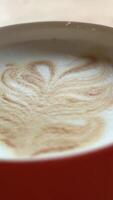 Cappuccino with latte art in a beautiful cup on the table in a cafe. video
