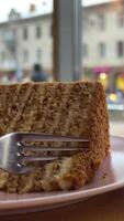 un' avvicinamento cattura il artigianale fascino di un' medovik miele torta fetta, quale è pensieroso assaggiato con un' forchetta su un' finemente artigianale piatto video