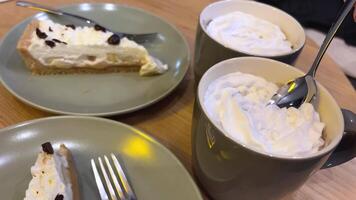 Due Mela e crema pasticciera crostate e Due tazze di caffè su un' piccolo il giro tavolo con un' bella fantasia tovaglia video