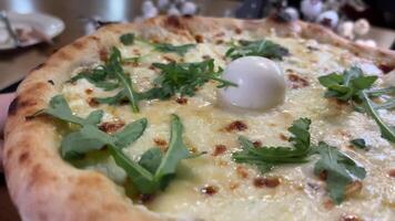 pizza é não uma de madeira borda. Preto fundo. fechar-se. italiano cozinha. quatro queijo pizza com Rúcula e mozzarella rasgado fora com mãos alongar queijo fechar-se cozido delicioso video