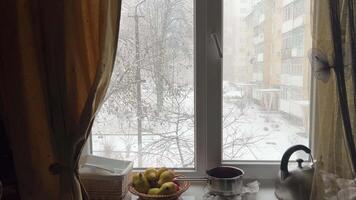 Aussicht von das Straße von das Küche Fenster, Schnee ist fallen im Winter auf Fensterbrett, Kessel von Birnen. gewöhnliche Leben von echt Menschen im das Haus, Aussicht von das kalt Straße, Hof video