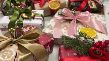 New Year's holiday atmosphere, winter fairy tale and Christmas spirit at home. Gift red packages with ribbons under a green tree. Slow motion. Decorated Christmas tree with lights, balls and presents. video