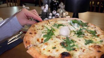 Pizza with mushrooms, ham and cheese. Italian cuisine. Side view. Rotates. four cheese pizza with arugula and mozzarella torn off with hands stretches cheese close-up baked delicious video