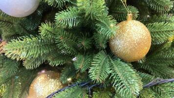 detailopname, naadloos lusvormige . kunstmatig Kerstmis boom versierd met zilver ballen draait Aan een wit achtergrond. Kerstmis achtergrond met groen Spar takken met decoraties. video