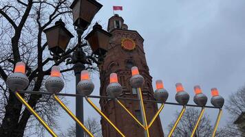 Hanukkah lights glow against the backdrop of a winter city of bare trees and sky lanterns close up of Hanukkah Doughnuts being sprinkled with powdered sugar in slow motion video