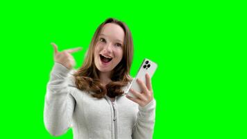 Guarda qui. contento donna mostrando vuoto smartphone schermo e puntamento su esso, bianca sfondo video