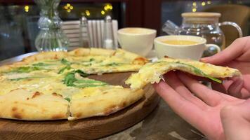 taking slice of pizza with super stretching stretchy cheese Pizza with cheese and arugula, a hand pulls a delicious freshly baked piece. fresh pizza video